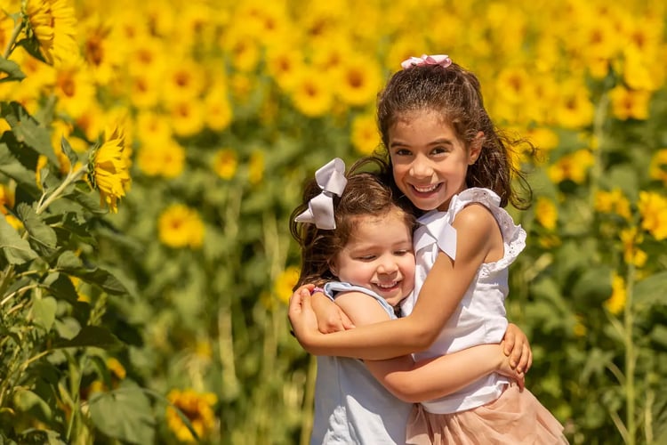 summer-children-hugging-yellow-sunflowers